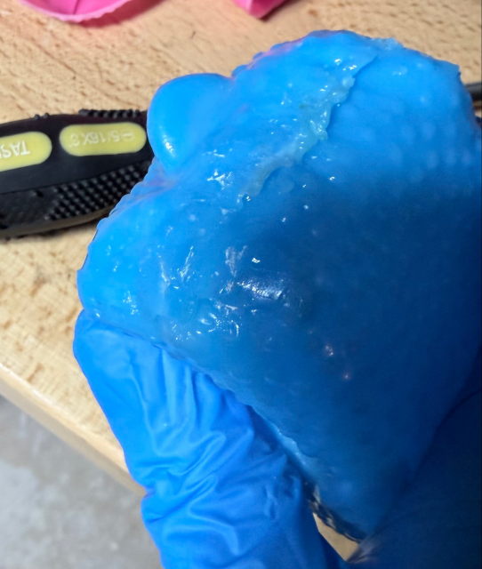 A blue rubber chicken with the bottom of the bellows sealed up and welded closed