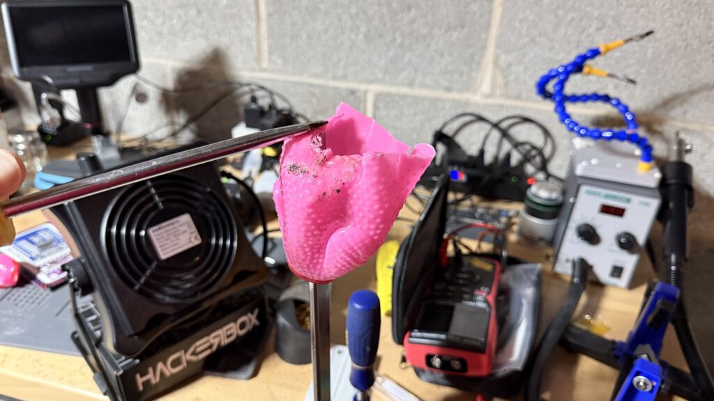 A wide-blade screwdriver was used to hold the piece, and compress the softened vinyl.