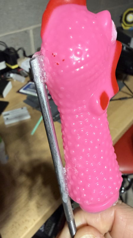 A pink rubber chicken head, successfully mounted on a steel rod.
