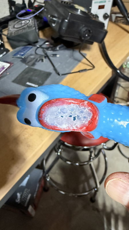 A blue chicken head with a mouth full of super glue gel.